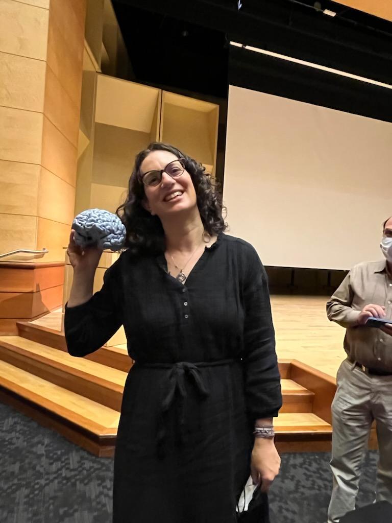 A picture of Cheryl Kaiser holding a 3D printed model of her brain